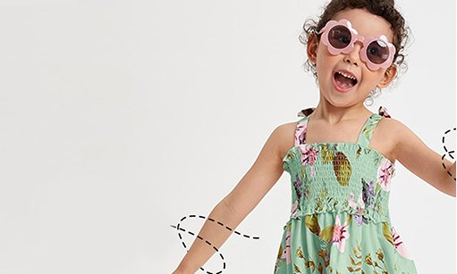 Girl in a green floral dress wearing sunglasses